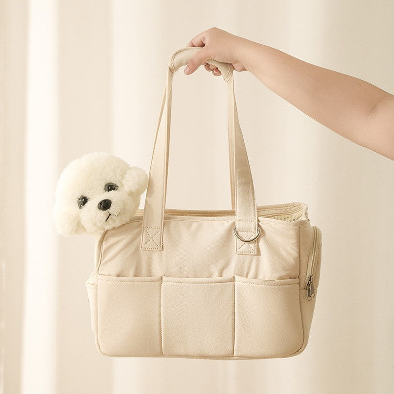 Beige tote bag with a white teddy bear inside, held by a hand against a light background