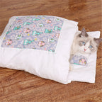 Cat lying on a colorful patterned cushion with a white border on a wooden floor.