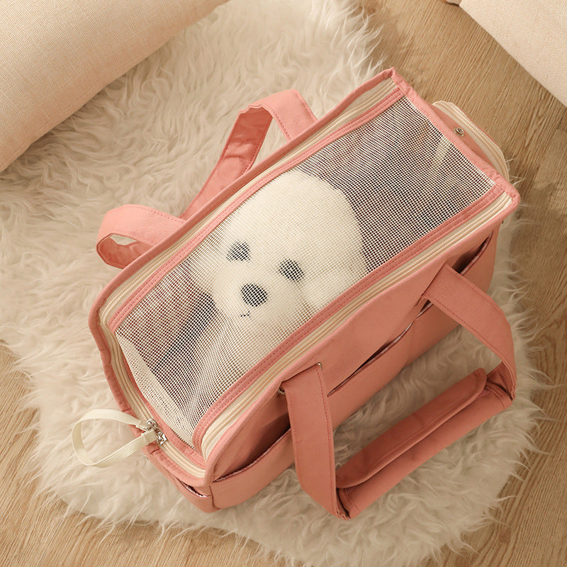 Pink pet carrier with transparent door on a fluffy white surface