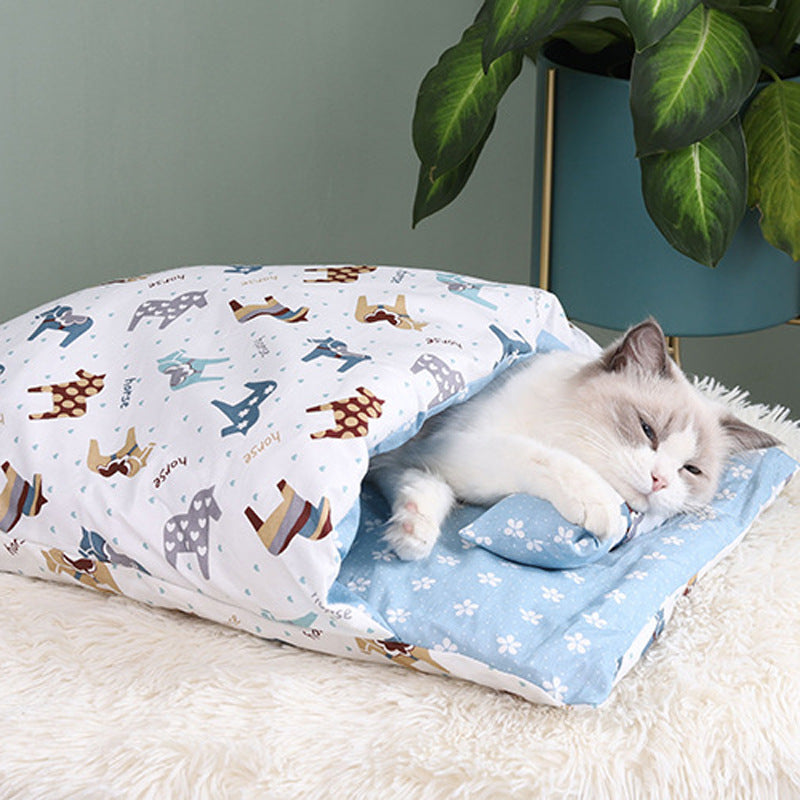 Cat lying on a patterned blanket with cartoon animals on a soft surface.