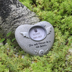 Heart-shaped pet memorial stone with engraved text in a garden setting