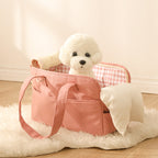 White fluffy dog in a pink pet carrier on a soft surface
