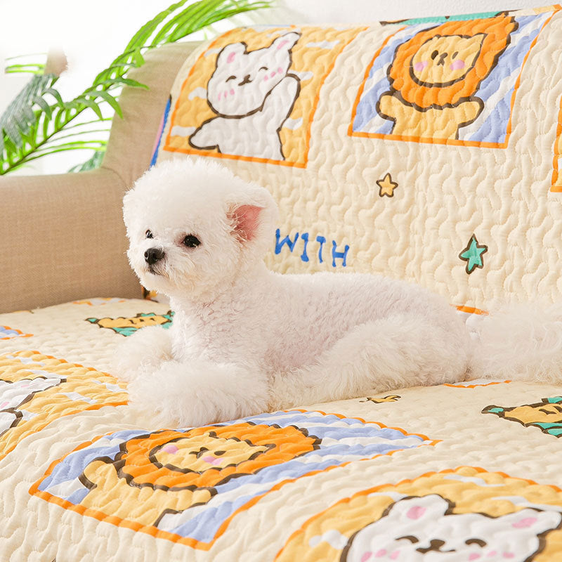 Small white dog sitting on a colorful quilt with cartoon animal designs.