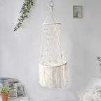 Macrame hanging chair with lights on a white wall with decorative elements.